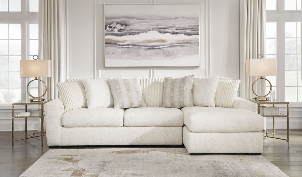 Ivory sectional sofa with chaise section and tuft-like seat detailing, styled with accent pillows