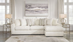 Ivory sectional sofa with chaise section and tuft-like seat detailing, styled with accent pillows