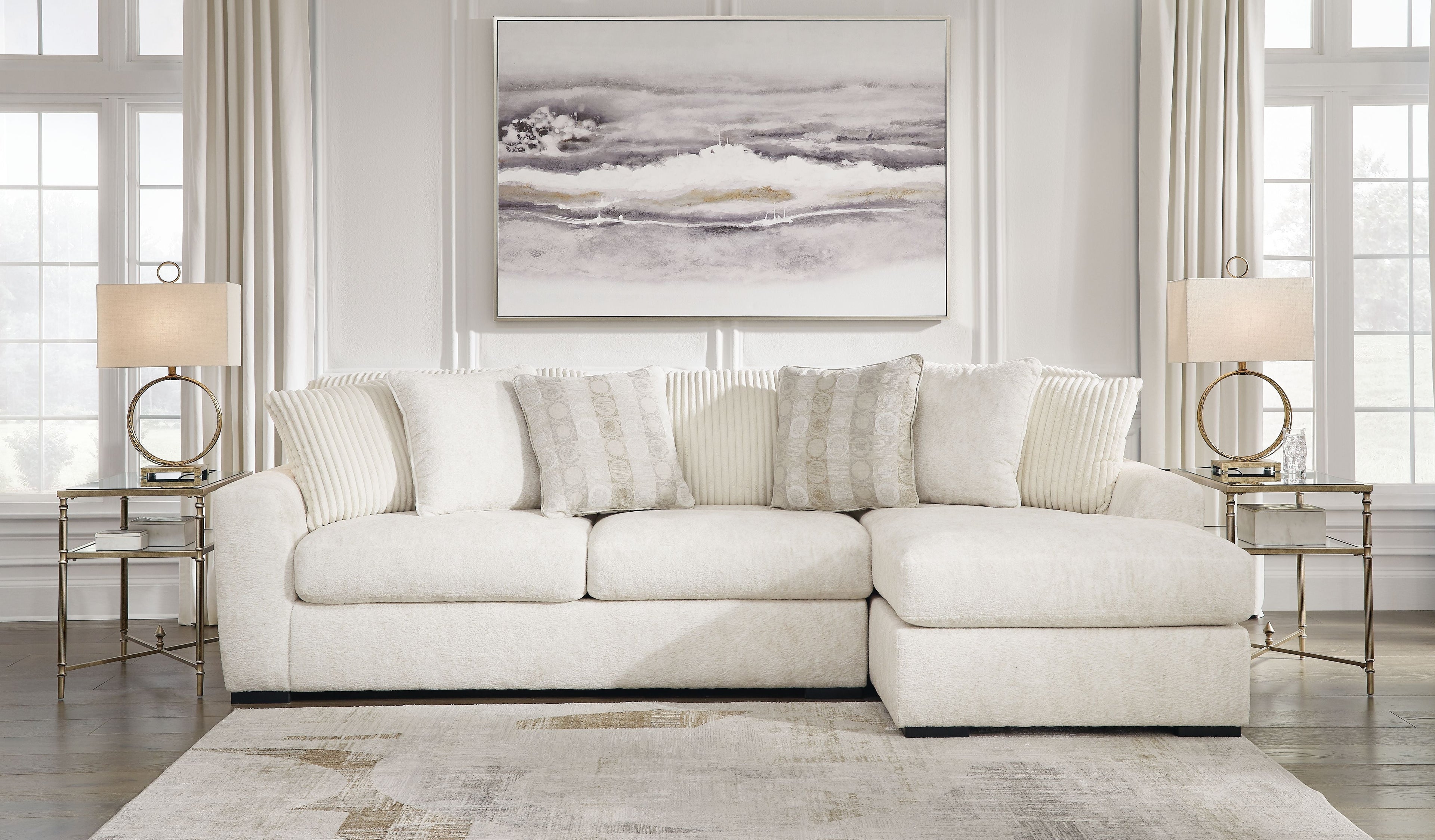Ivory sectional sofa with chaise section and tuft-like seat detailing, styled with accent pillows