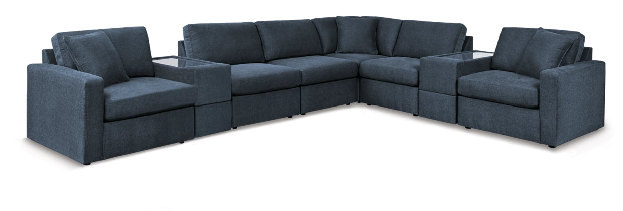 Modular sectional sofa in dark blue fabric with rounded arms and boxy seat cushions