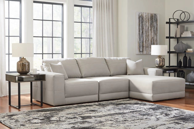 Light gray sectional sofa in an open layout, chaise section and tufted back cushions