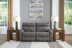 Gray power reclining loveseat with two recliners and padded headrests