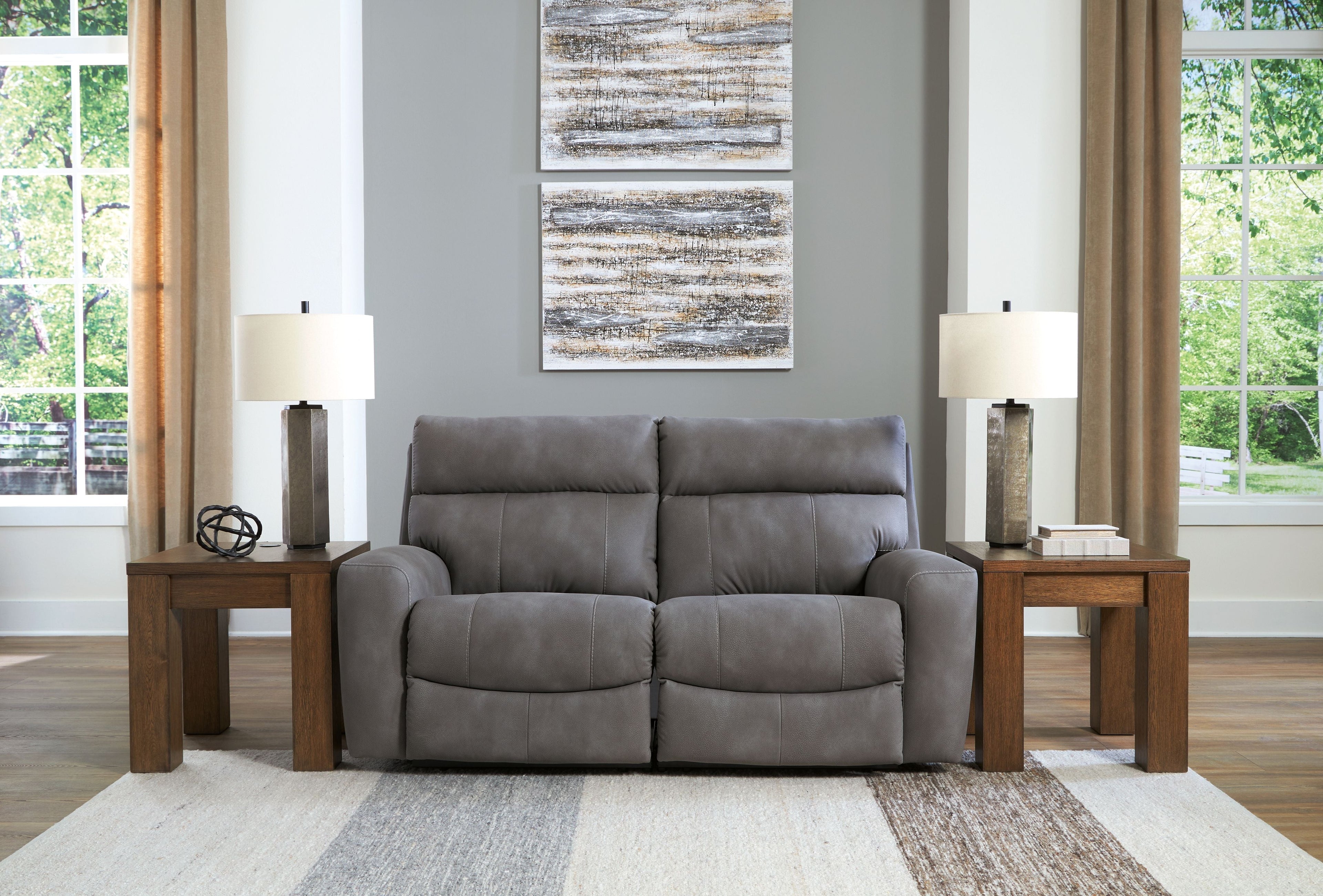 Gray power reclining loveseat with two recliners and padded headrests