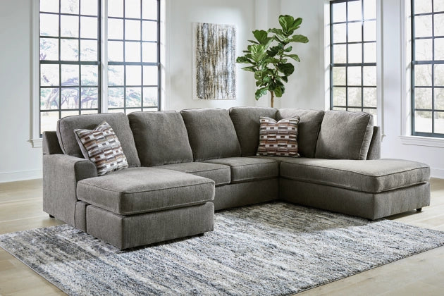 Gray sectional sofa with corner chaise, square armrests, and throw pillows