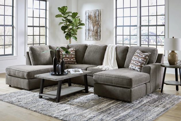 Gray sectional sofa with chaise ottoman, accent pillows, and square arm cushions