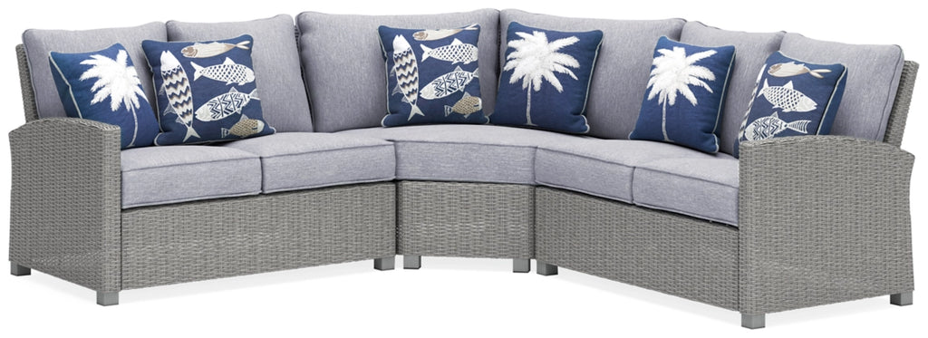 Light gray outdoor sectional sofa with three back cushions and blue patterned pillows