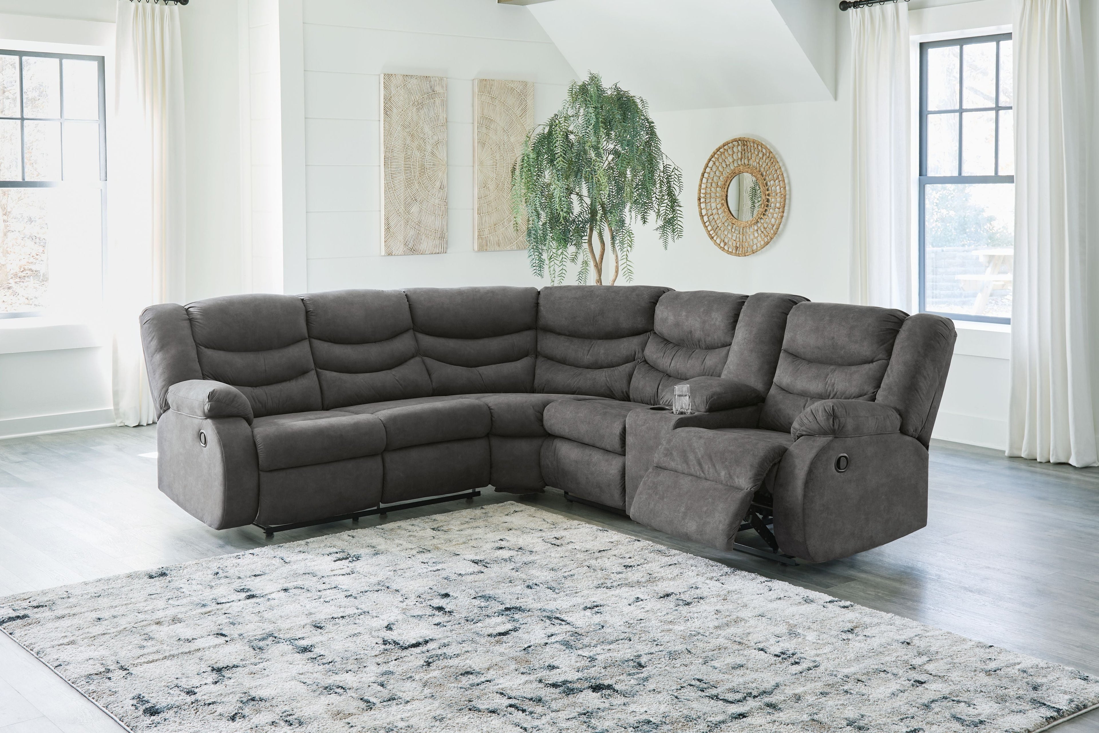 Slate gray reclining sectional sofa with chaise, tufted seat cushions, and recline arms