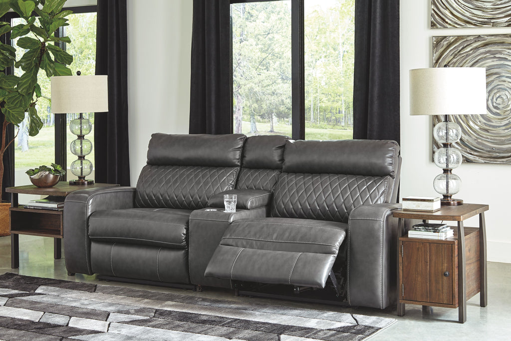 Gray power reclining loveseat with padded headrests and chaise footrest