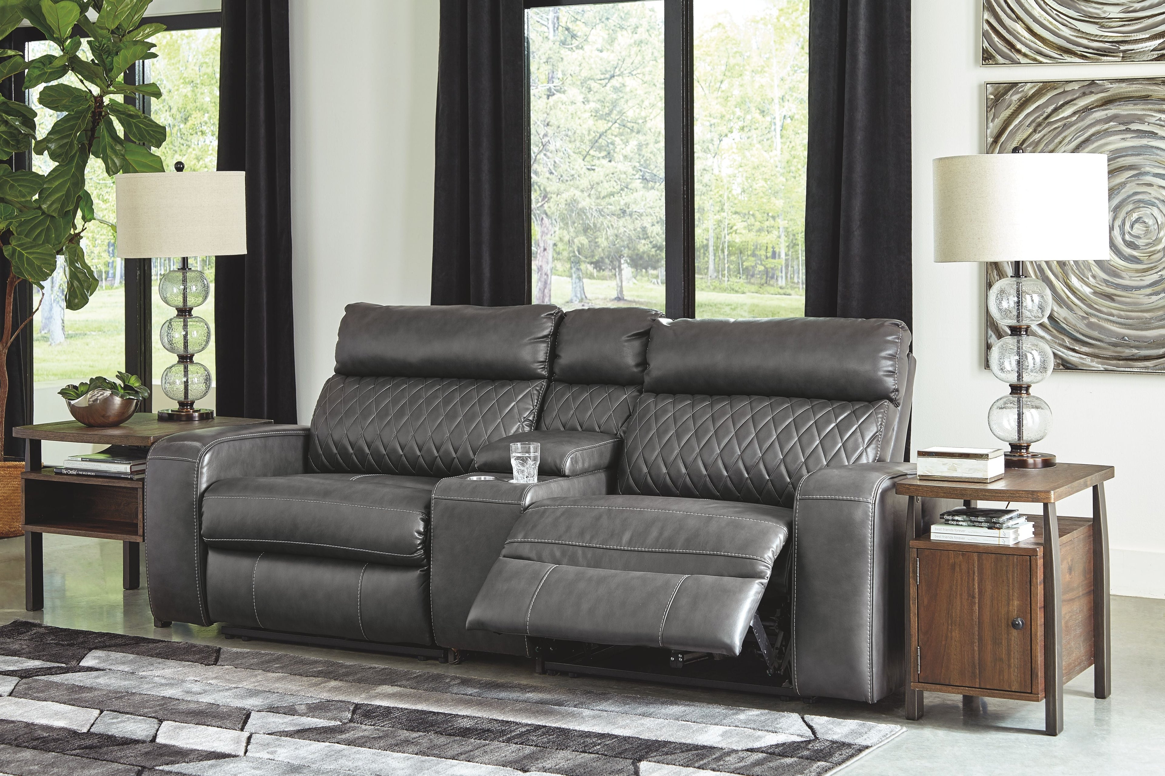 Gray power reclining loveseat with padded headrests and chaise footrest