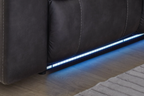 Dark carbon reclining sectional with glowing LED strip along the base and stitched cushions.