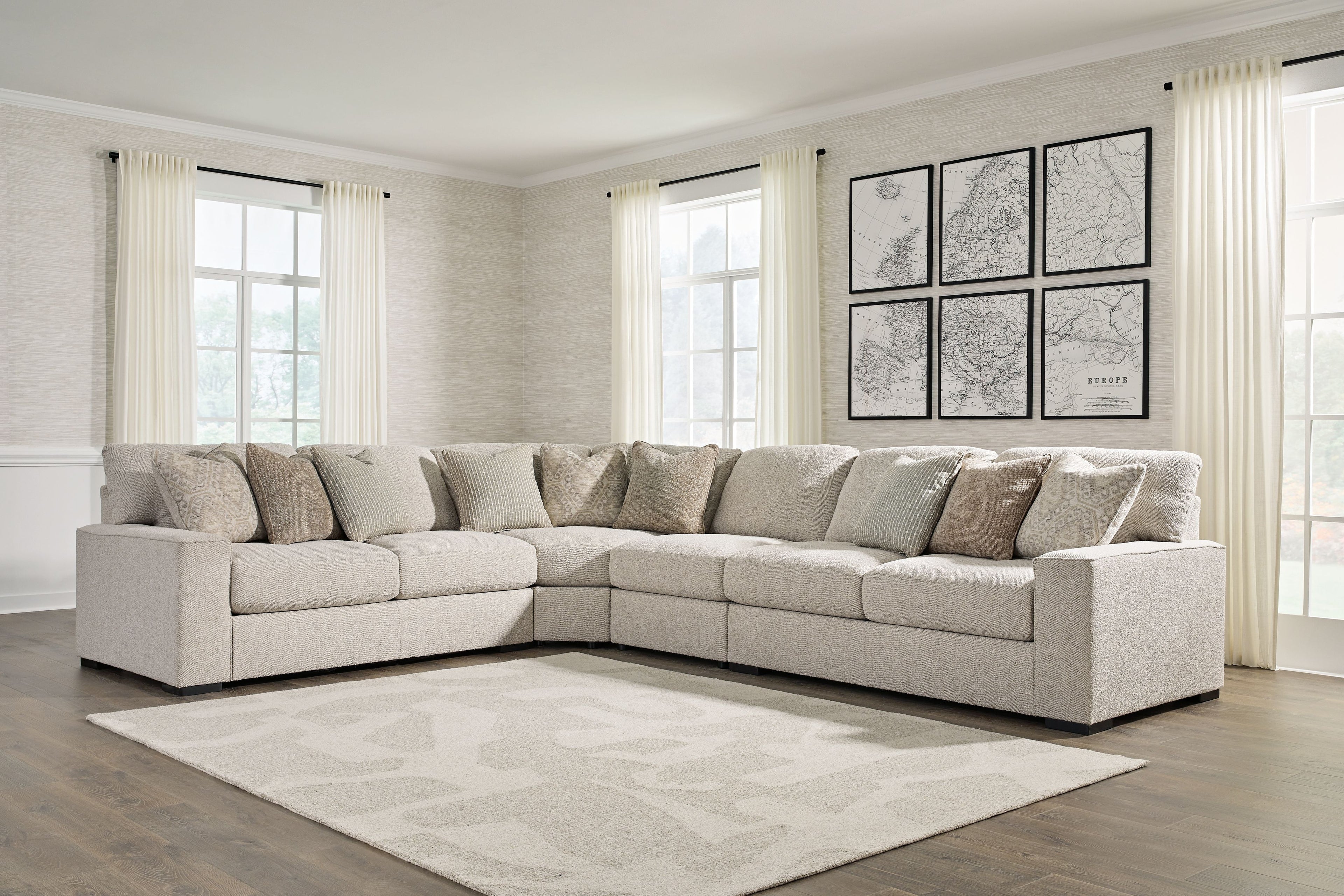 Sand beige sectional sofa with chaise corner and patterned pillows, black feet on base