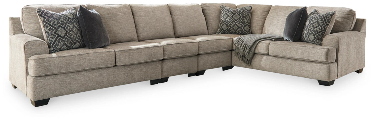 Stone sectional sofa with chaise section, decorative geometric pillows and dark base