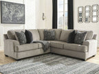 Stone sectional sofa with dark patterned accent pillows and corner chaise