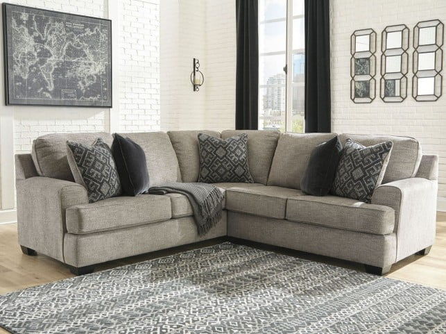 Stone sectional sofa with dark patterned accent pillows and corner chaise
