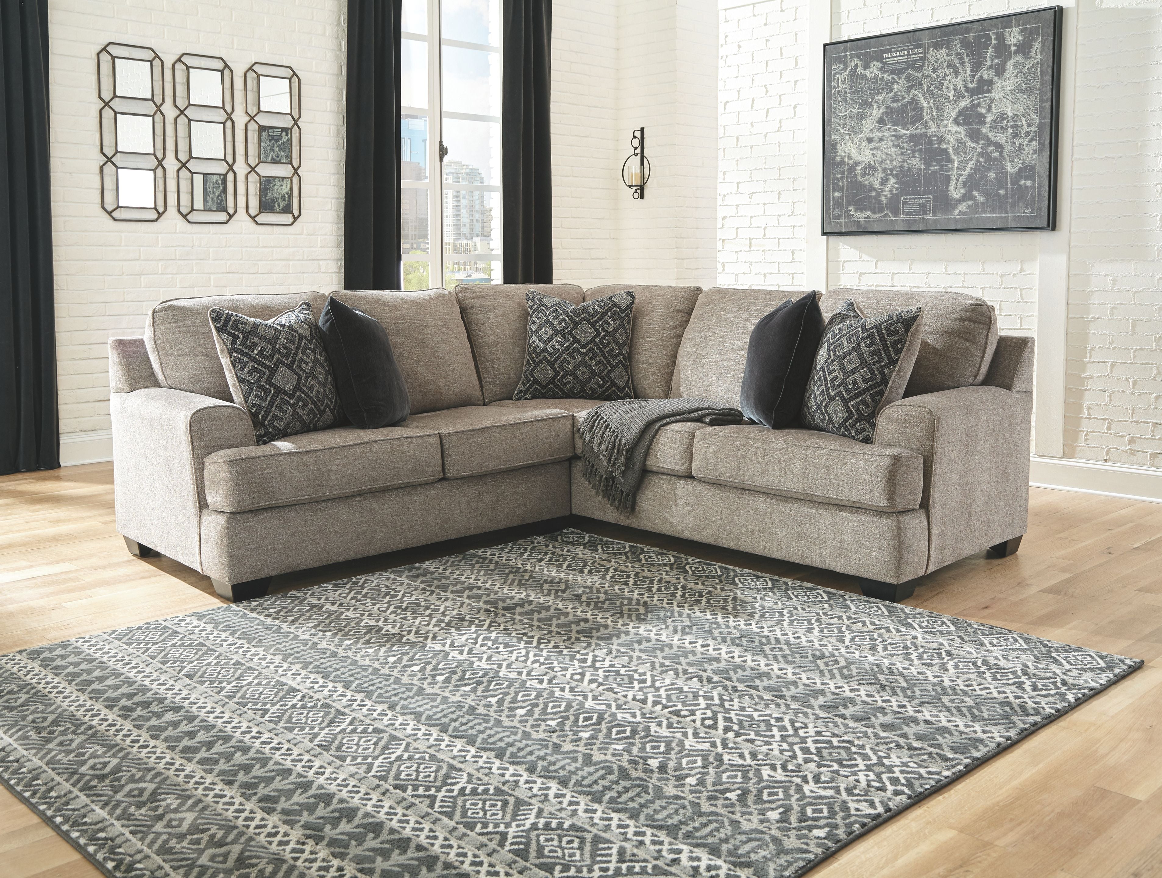 Stone fabric sectional sofa with multiple patterned throw pillows and corner chaise