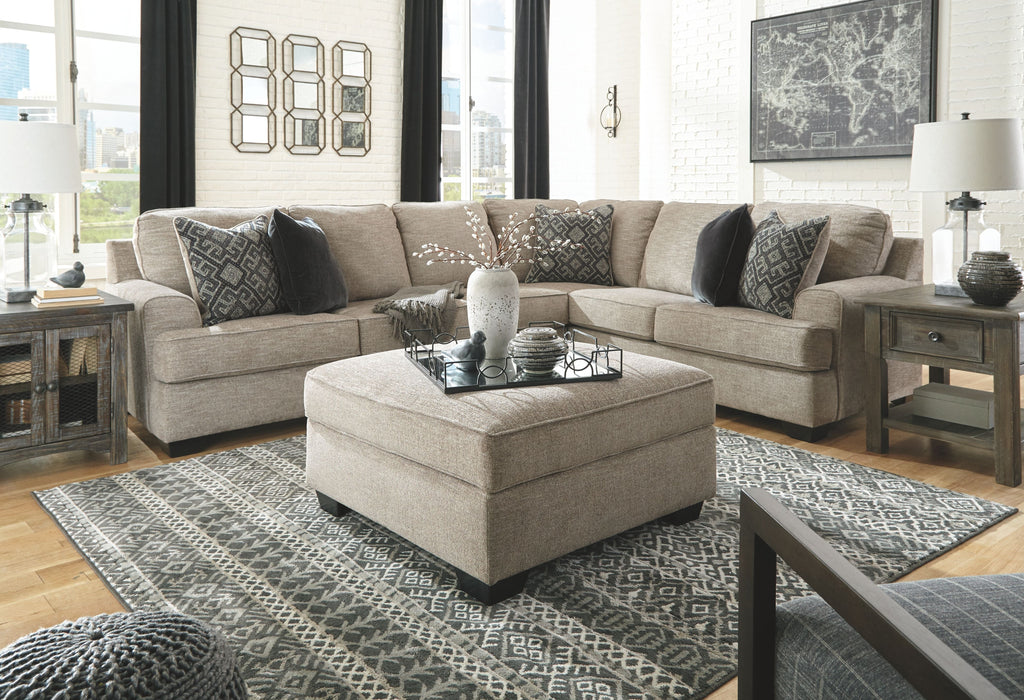 Stone sectional sofa with corner chaise, patterned accent pillows, and glass table centerpiece