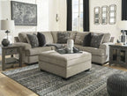 Stone sectional sofa with corner chaise and patterned pillows with small ottoman in front