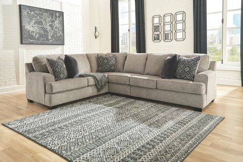 Stone fabric sectional sofa with patterned throw pillows and chaise corner layout