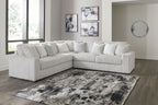 Light gray sectional sofa with corner chaise and stacked back pillows, ribbed upholstery