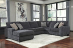 Dark gray sectional sofa with chaise and accent pillows, upholstered in textured fabric