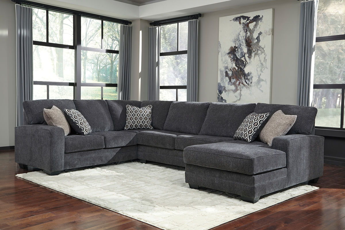 Dark gray sectional sofa with chaise extension and patterned accent pillows