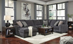 Dark gray sectional sofa with chaise, decorative pillows, and wide padded back cushions