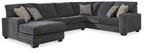 Dark gray sectional sofa with left-facing chaise, padded armrests, and throw pillows