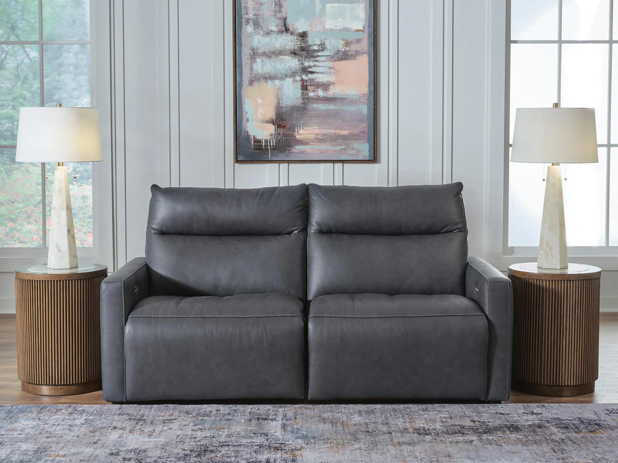 Dark gray power reclining sofa with padded arms and tufted seat back panels