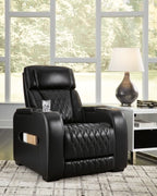 Black power recliner with quilted backrest and side handle, in front of windows