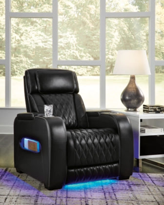 Black power recliner chair with adjustable headrest and armrest controls, upright