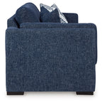 Blue upholstered chair with striped accent pillow and back cushion