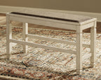 Beige counter bench with upholstered seat and open lower shelf underframe