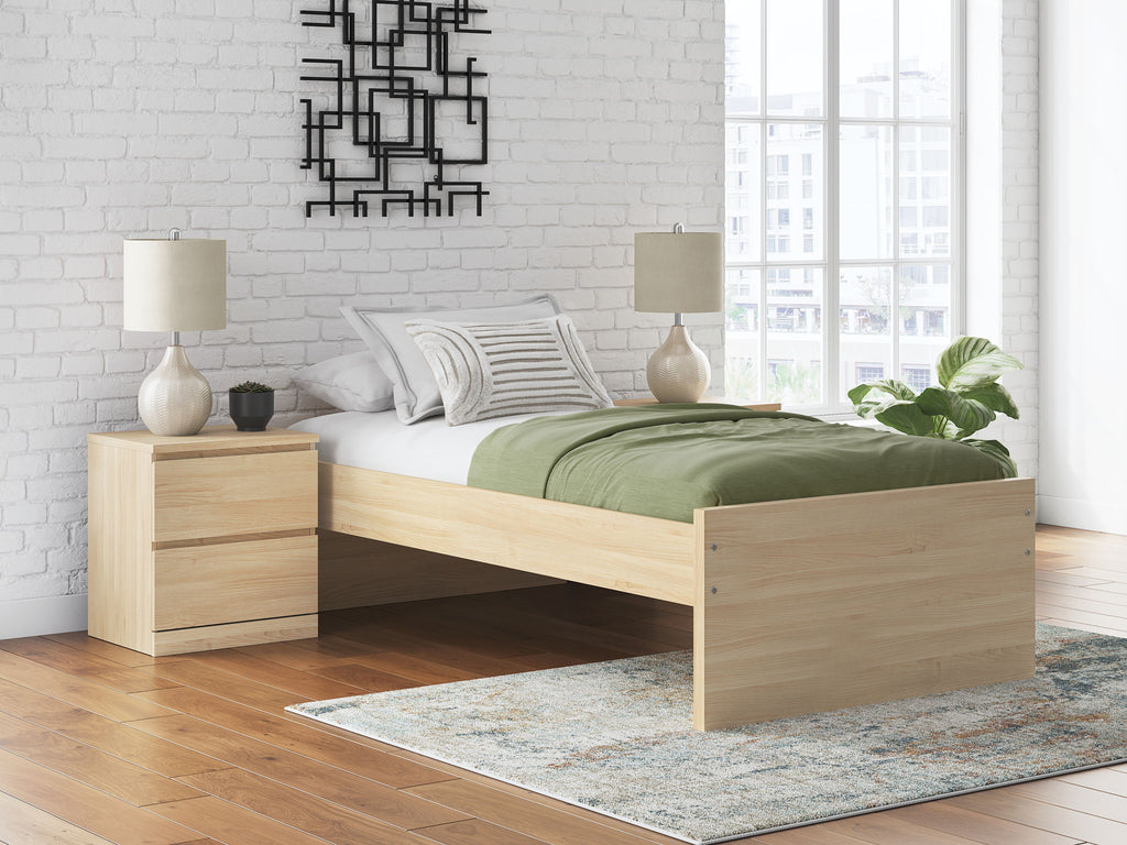 Light wood platform bed with side drawers and headboard, shown with bedding