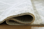 Gray rug corner with short pile texture and tan backing underside