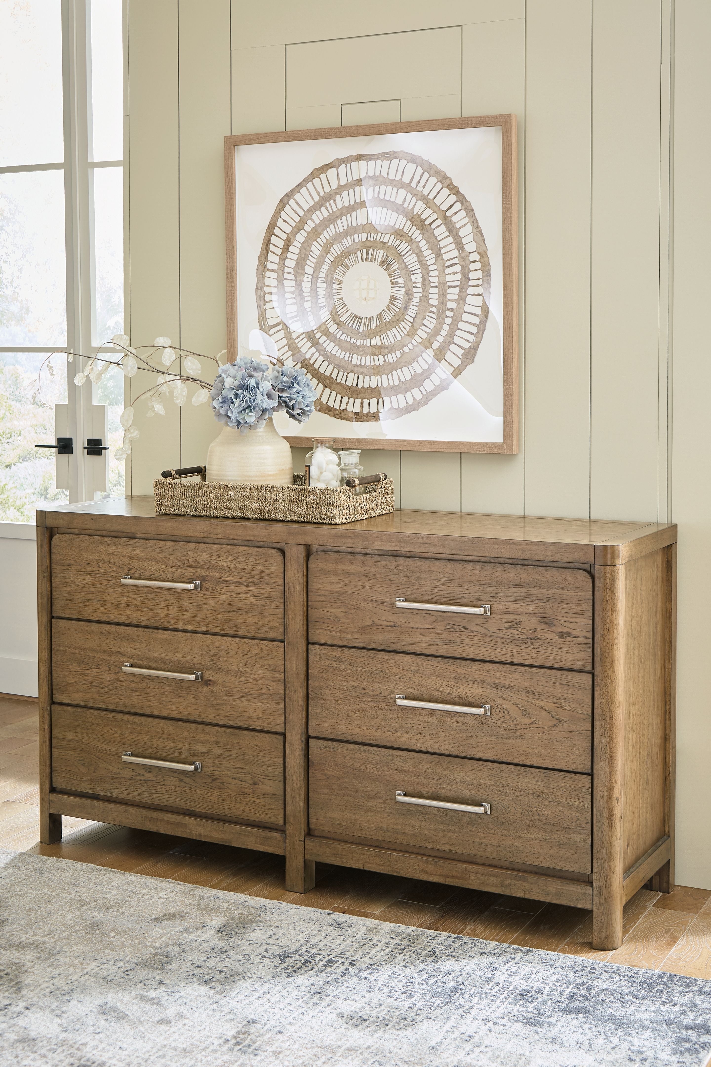 Light brown wooden dresser with six drawers and metal bar pulls, front-left view