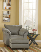 Dark gray upholstered armchair with matching ottoman, rounded arms and wide seat