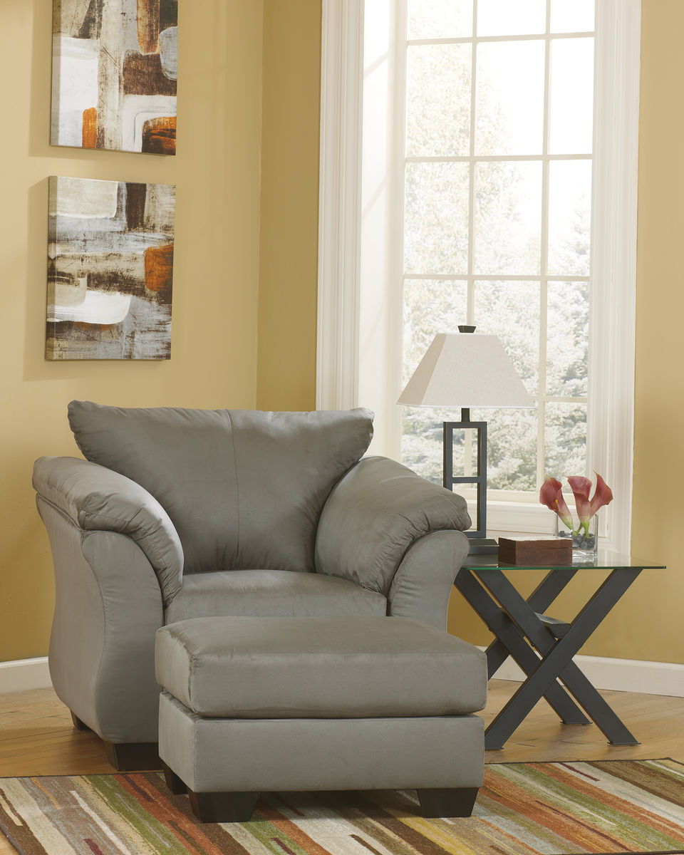 Dark gray upholstered armchair with matching ottoman, rounded arms and wide seat