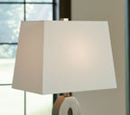 Table lamp with off-white drum shade and top of gray cutout base