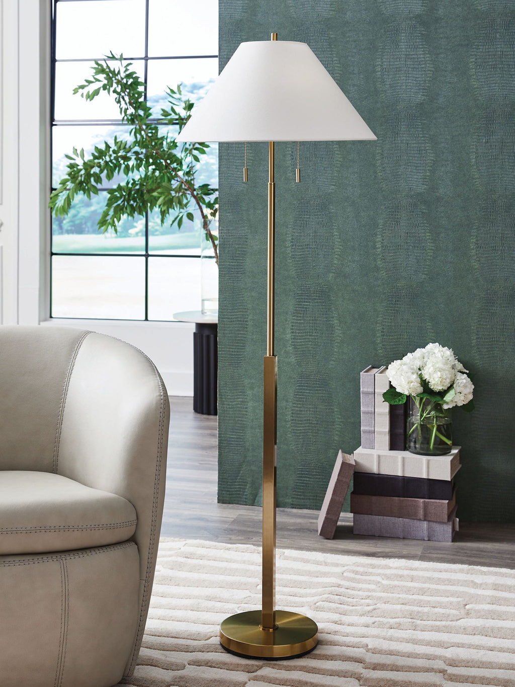 Gold floor lamp with white shade, round base, and two hanging pull cords.