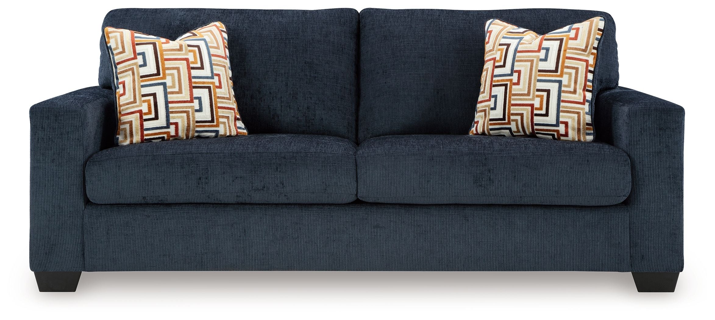 Ink sofa sleeper in dark blue with two patterned throw pillows, long front view.