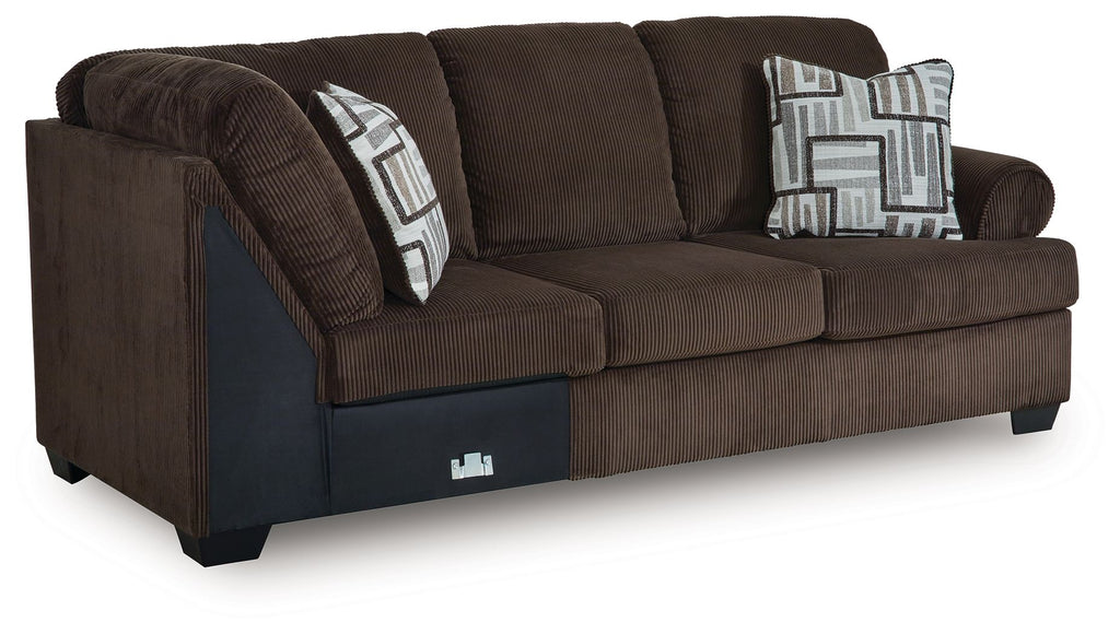 Chocolate-brown upholstered sofa with corner wedge and two geometric throw pillows