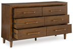 Dark brown wooden dresser with six drawers and rectangular brass pull handles