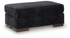 Black upholstered ottoman with cushioned top and wooden legs, square profile