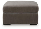 Gray upholstered accent ottoman with thick padded top and front-facing block legs