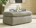 Gray upholstered ottoman with rounded lid and blocky base
