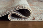 Rolled edge of distressed area rug with textured border and underside