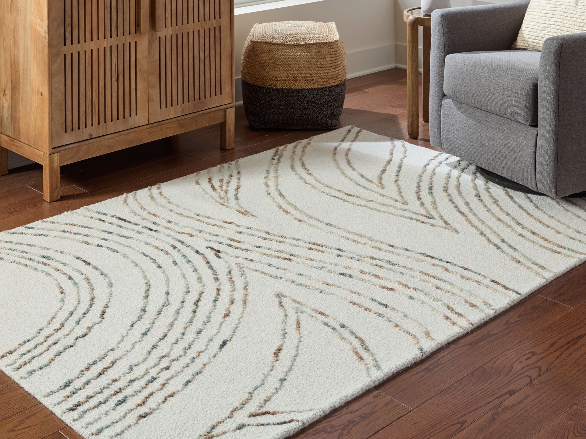 Deenbury rug laid in living room with off-white and beige swirl lines