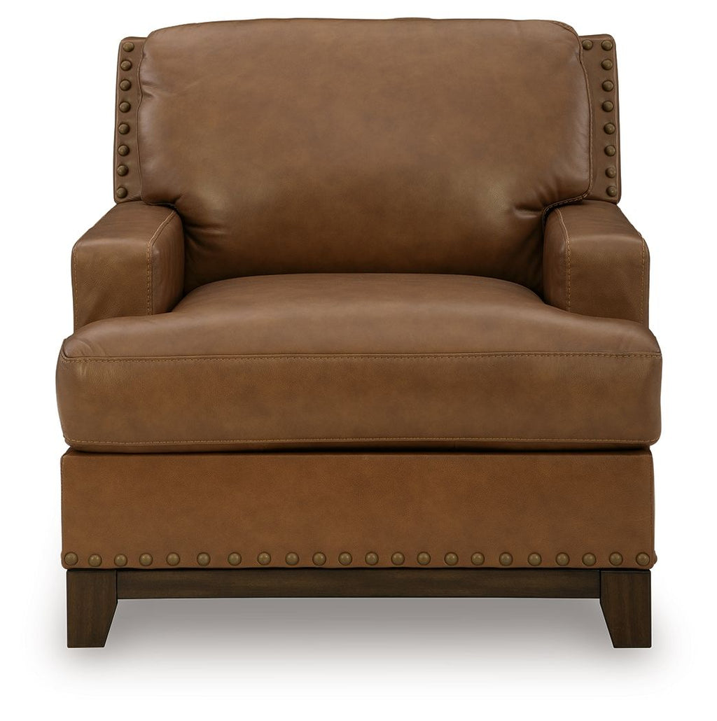 Amber leather armchair with nailhead trim, cushioned seat, and tall backrest