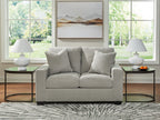 Light upholstered loveseat with four throw pillows and two seat cushions
