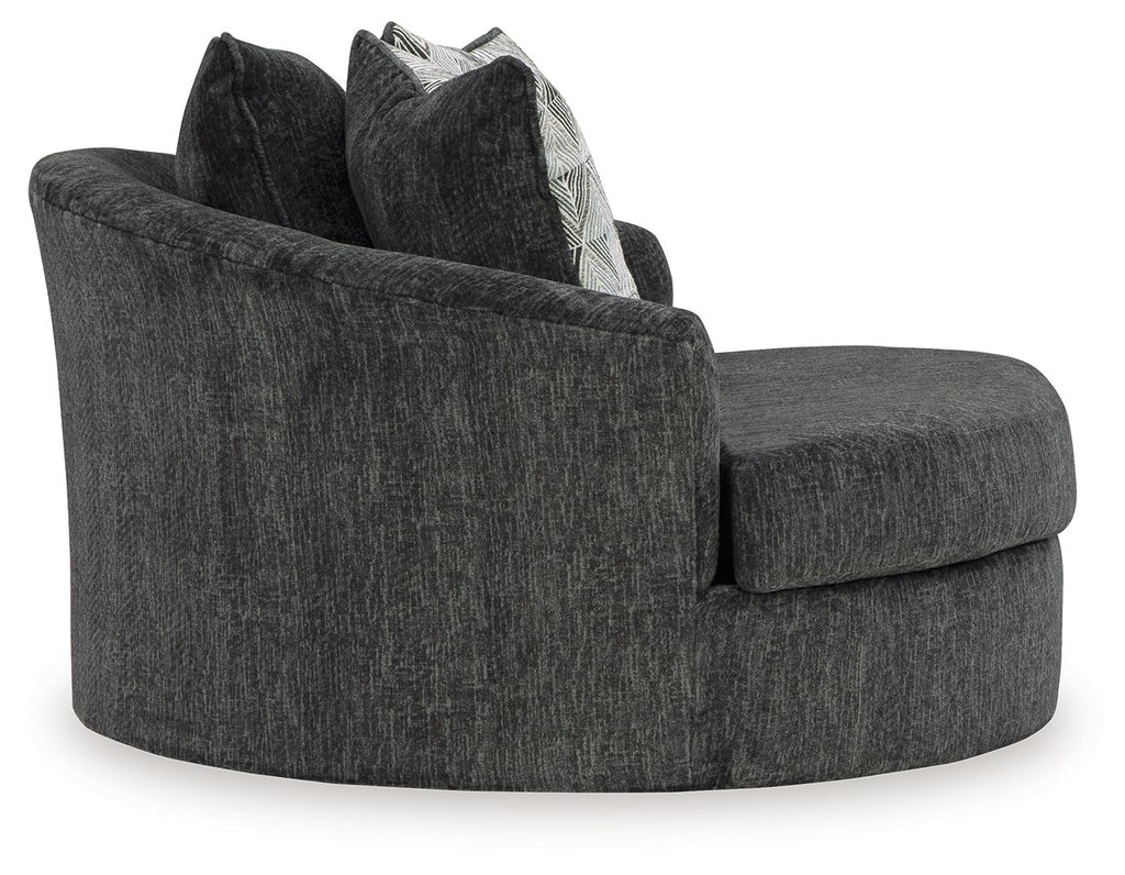 Dark gray oversized swivel accent chair with armrests and two stacked geometric pillows